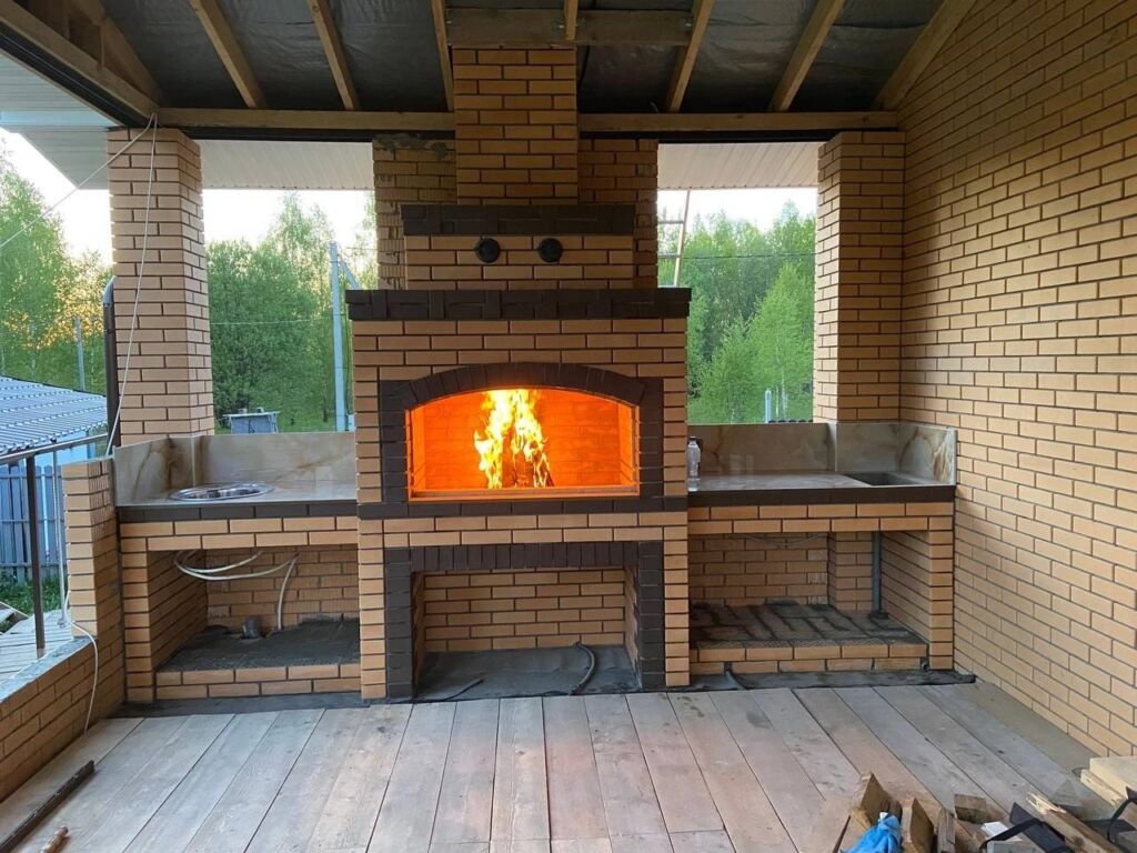 Печь-барбекю из кирпича на открытой террасе загородного дома